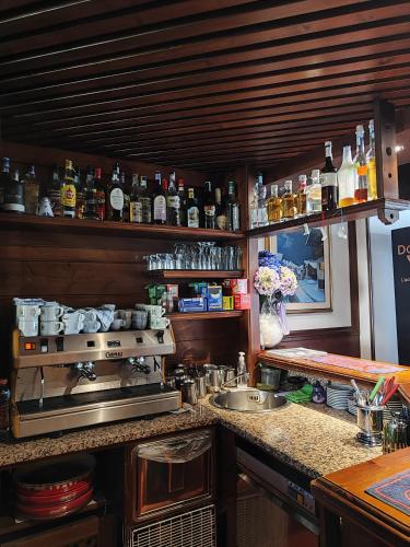 a kitchen with a stove and a counter with alcohol bottles at Al Sole Hotel Ristorante dal 1870 in Pieve di Cadore