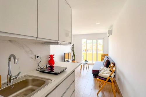 a kitchen with white cabinets and a red vase on the counter at OleHolidays 624 Duplex Carib Playa 200 mts. playa in Marbella