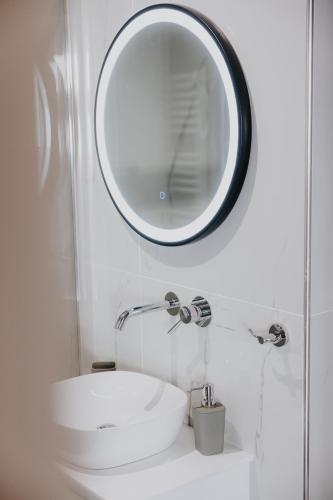 a bathroom with a sink and a mirror on the wall at Pearl Apartel in Volos