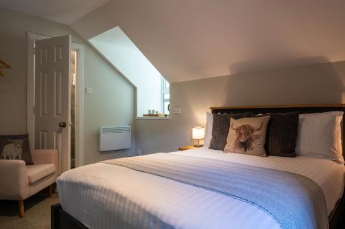a bedroom with a large white bed and a chair at Coolin View in Portree