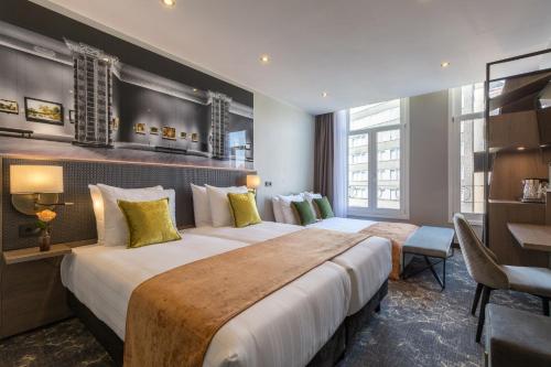 a hotel room with two beds and a desk at Leonardo Boutique Museumhotel in Amsterdam