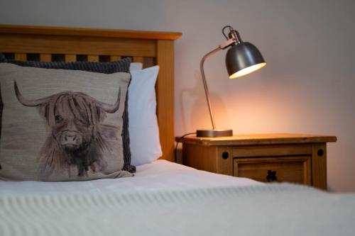 a bed with a pillow with a bull on it at Coolin View in Portree