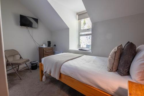 a bedroom with a bed and a television and a chair at Coolin View in Portree