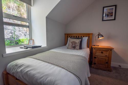 a bedroom with a bed and a window at Coolin View in Portree