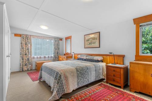 een slaapkamer met een bed en een raam bij Hatea Drive Accommodation in Whangarei