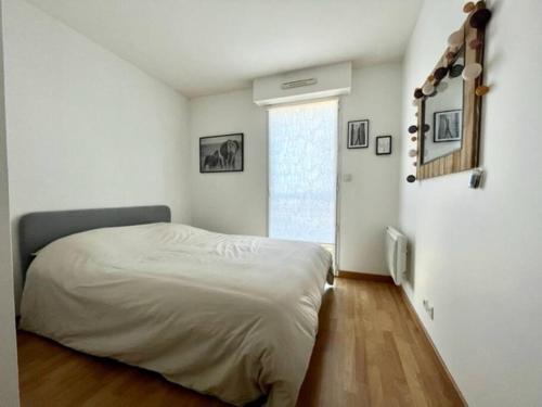 - une chambre blanche avec un lit et une fenêtre dans l'établissement Appartement cosy jardin des plantes avec parking, à Nantes