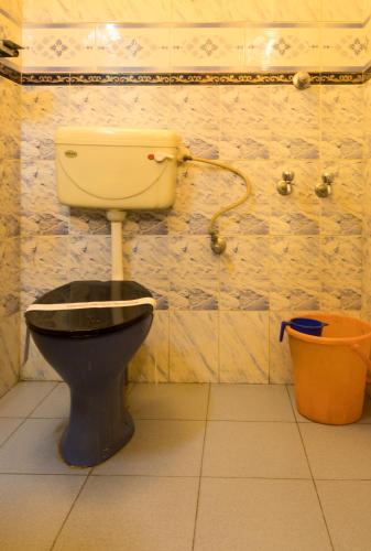 a bathroom with a toilet and a bucket at Wintergreen Water Front Resort- 5 Bedroom Villa in Tripunittura