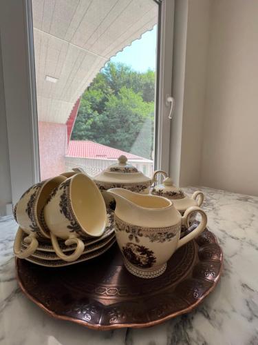 una pila de tazas de té y platillos sobre una mesa en Guest House Gaenati, en Kutaisi
