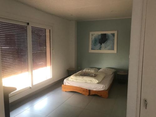 ein Schlafzimmer mit einem Bett in einem Zimmer mit einem Fenster in der Unterkunft Port nivelle IBAIAN in Saint-Jean-de-Luz