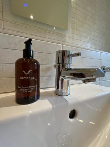 butelka mydła na zlewie w łazience w obiekcie Cornish Beach Lodge w mieście Torpoint