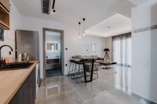 a kitchen and living room with a table and chairs at Pearl Apartel in Volos