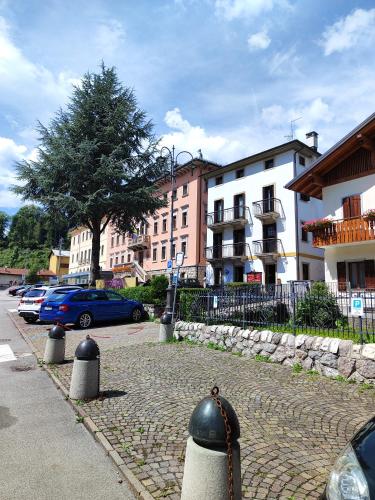 a cobblestone street with buildings and cars in a city at Al Sole Hotel Ristorante dal 1870 in Pieve di Cadore