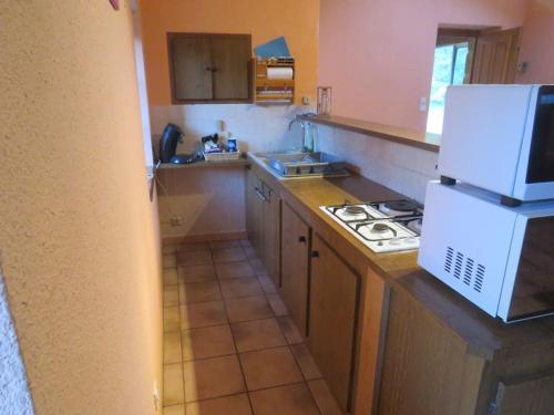 a kitchen with a stove and a white refrigerator at Maison de vacances en Ardèche in Pailharès