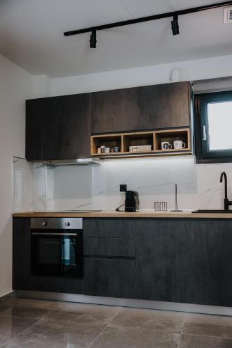 a kitchen with black cabinets and a counter top at Pearl Apartel in Volos