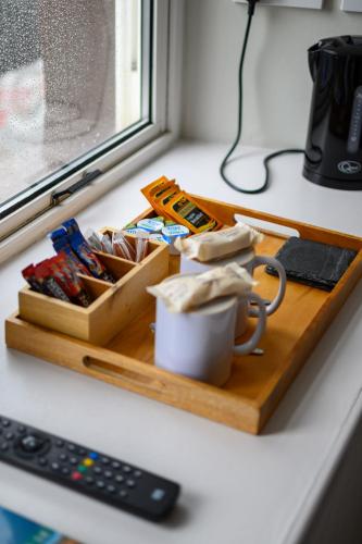 a wooden tray with a cup of coffee and a remote control at Coolin View in Portree