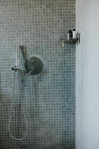 a shower in a bathroom with a tile wall at Pearl Apartel in Volos