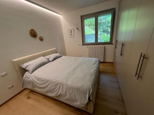 a small bedroom with a bed and a window at Verbano Boutique Apartment in Meina