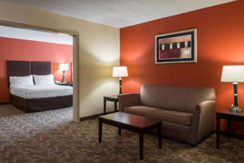 a hotel room with a couch and a bed at Holiday Inn Express & Suites Lexington Downtown Area-Keeneland by IHG in Lexington