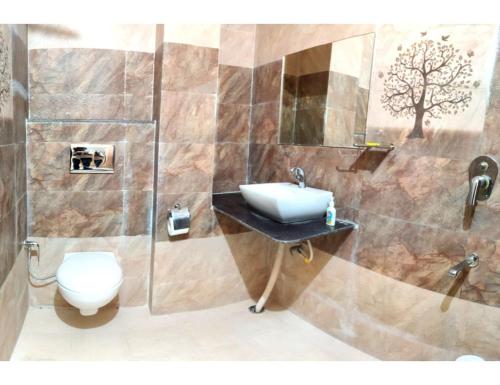 La salle de bains est pourvue d'un lavabo et de toilettes. dans l'établissement Hotel Pragati, Chanderi, MP, à Chanderi