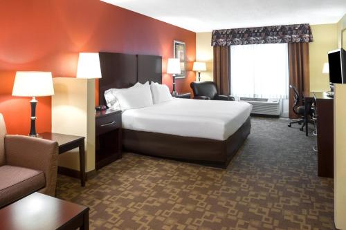 a hotel room with a large bed and a couch at Holiday Inn Express & Suites Lexington Downtown Area-Keeneland by IHG in Lexington