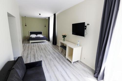 Una pequeña sala de estar con una cama y un televisor. en Hotel Golden lemon Готель Золотий лимон, en Leópolis