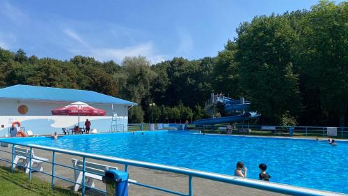 a large swimming pool with a slide and people in it at Kemping Obora in Racibórz
