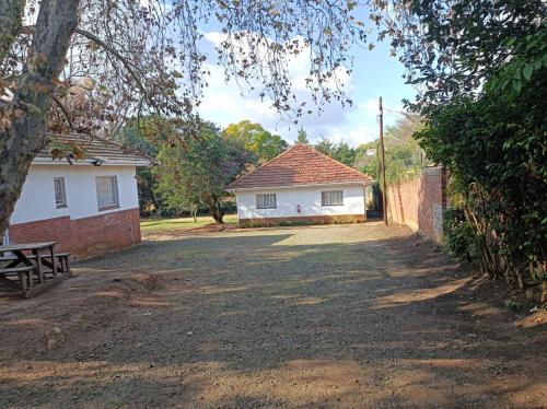 a white house with a bench in front of it at Danodeb Lodge in Pietermaritzburg