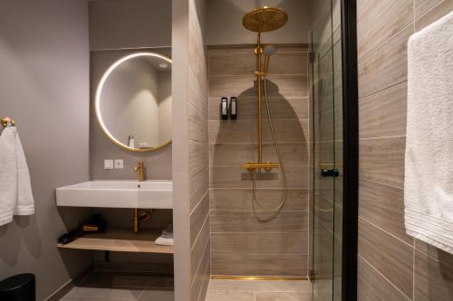 uma casa de banho com um chuveiro e um lavatório. em Hotel Hvide Falk em Ilulissat