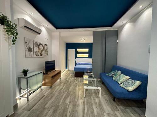 een woonkamer met een blauwe bank en een bed bij Loft Vialia Centro in Málaga