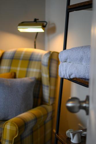 a living room with a yellow and blue couch and a lamp at Coolin View in Portree