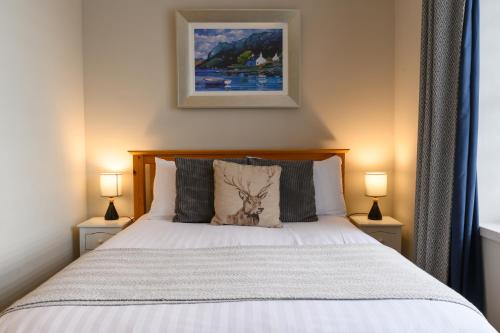 a bedroom with a white bed with two lamps at Coolin View in Portree