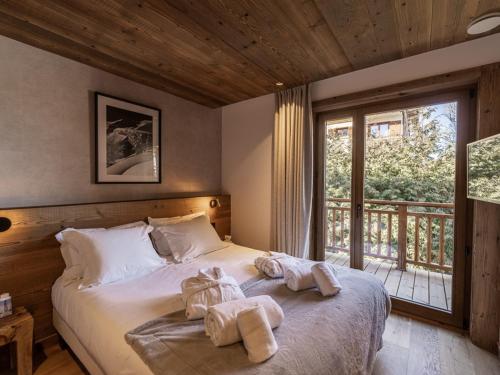 1 dormitorio con 1 cama con toallas en Chalet Courchevel, 6 pièces, 10 personnes - FR-1-568-33, en Courchevel