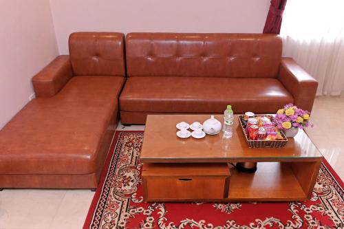 a living room with a brown couch and a coffee table at Khách sạn Hoàng Hà River Town in Yên Bái