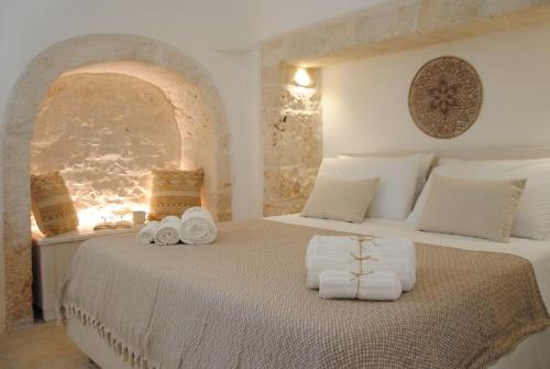 a bedroom with a bed with towels on it at Borgo Petra in Cisternino