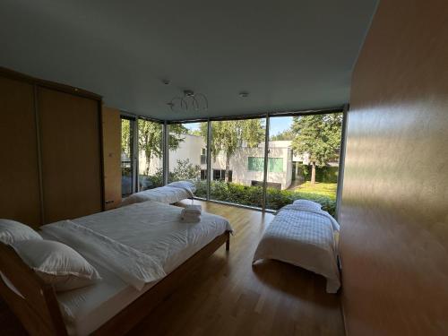 a bedroom with two beds and a large window at Merirahu private luxury villa in Tallinn