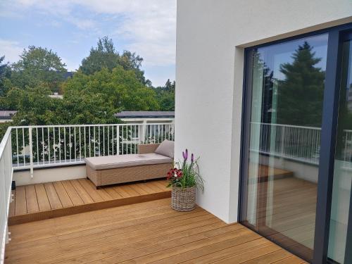 a balcony with a couch on a wooden deck at Apartamenty HELIOS in Jastrzębia Góra