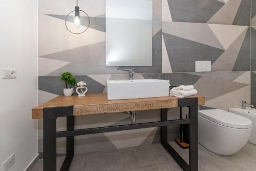 a bathroom with a sink and a toilet at Coste Ponente Appartamenti Turistici in Ragusa