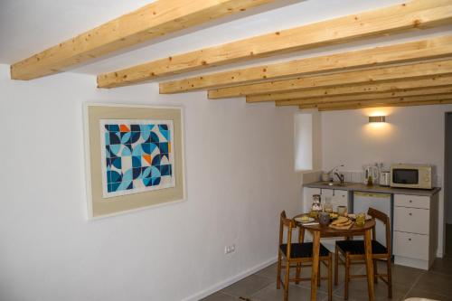 a kitchen with a table and chairs in a room at Casa das Pedras Country Retreat in Santo António das Areias