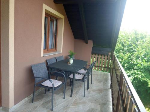 a porch with a table and chairs on a balcony at Apartman 2 RIBIČ in Ogulin