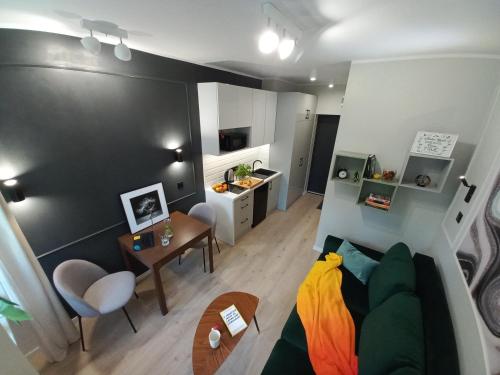 a living room with a couch and a table at Przytulne studio przy Atlas Arena i malowniczym parku in Łódź