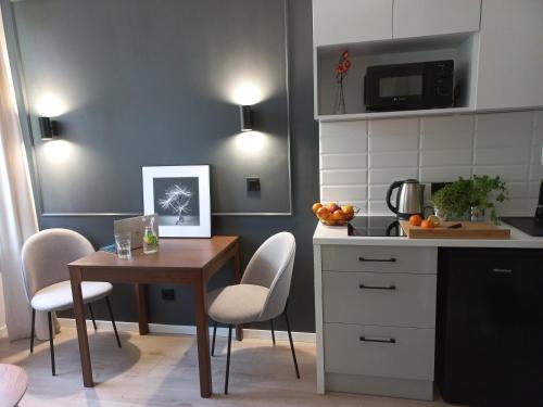 a kitchen with a table and a table and chairs at Przytulne studio przy Atlas Arena i malowniczym parku in Łódź