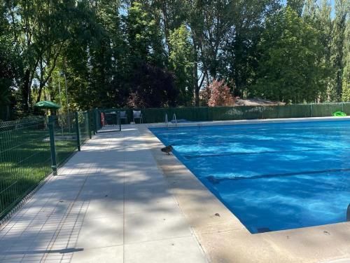 a swimming pool with blue water in a yard at Acogedora casa del siglo XIX in Bahabón