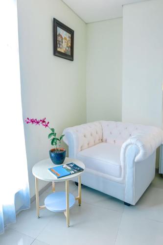 a living room with a white couch and a table at The Cube Hotel Malioboro, Azana Hotels Collection in Yogyakarta