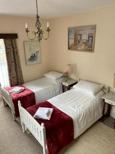 1 dormitorio con 2 camas y lámpara de araña en The Corner House Belford en Belford