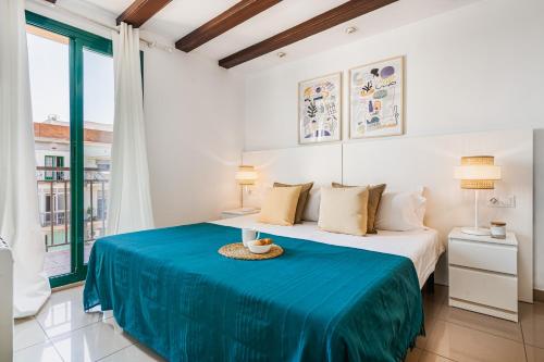 a bedroom with a large bed with a blue blanket at Lodging Apartments Liceu G1 in Barcelona