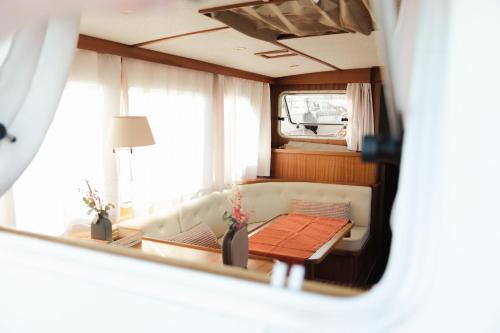 mit Blick auf ein Wohnzimmer mit einem Sofa und einem Tisch in der Unterkunft Hébergement insolite en demi-pension et excursion en bateau in Bouzigues