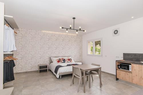 a bedroom with a bed and a table and a kitchen at Coste Ponente Appartamenti Turistici in Ragusa