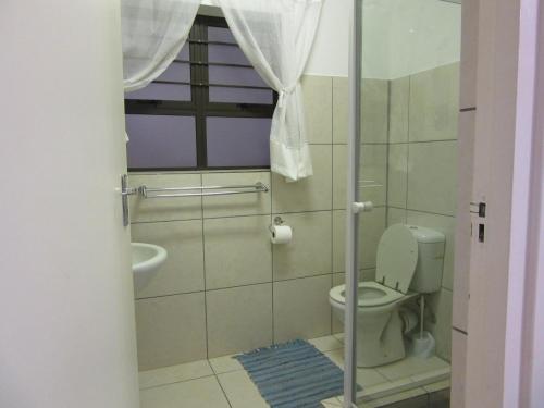 a small bathroom with a toilet and a window at Gretna Cottage in St Lucia