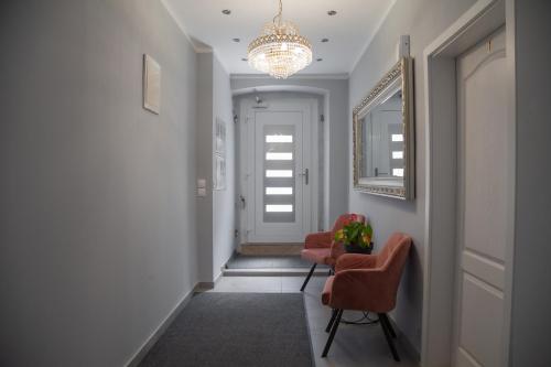 a hallway with two chairs and a chandelier at Captain Emo City Apartments in Pula