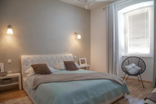 a bedroom with a large bed and a window at Captain Emo City Apartments in Pula
